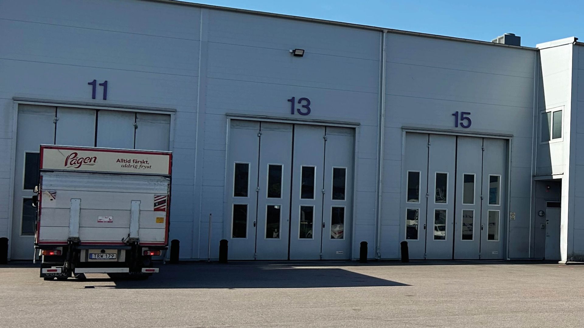 En lastbil utanför en byggnad med lastbilsportar